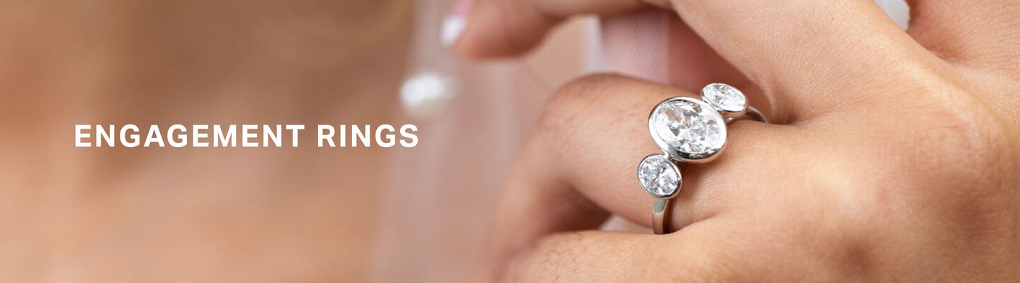 Luxury diamond engagement ring beside a bride in a veil, showcasing Fields engagement rings.